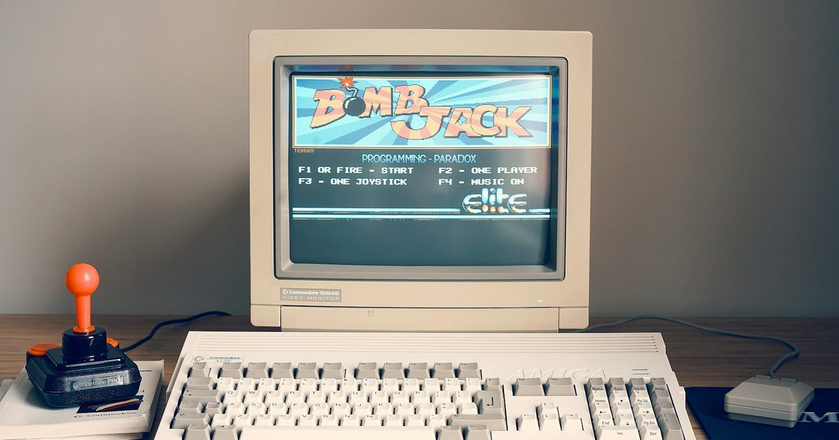 Beige retro computer, keyboard and joystick on a desk