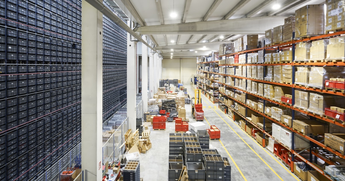 Warehouse aisle packed with boxes on tall shelves